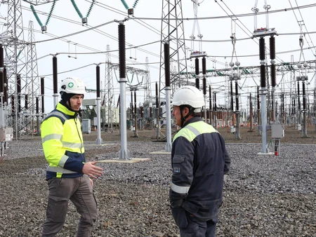 Two men in high viz out on site talking 