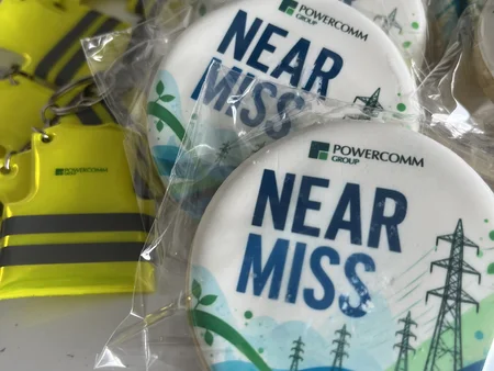 Cookie depicting power lines and wording "near miss" with high viz keyring