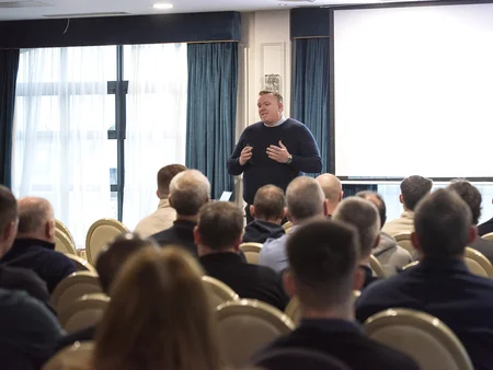 James Cafferty Powercomm Managing Director standing presenting to a crowd that's watching presentation on Safety Day. 