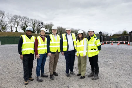A group of Powercomm staff celebrating the ESB launch day of the BESS 2 project, wearing high-vis jackets and white hard hats.