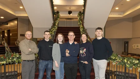 Six members of the Safety, Health, Environment, and Quality team stand on a landing in front of a staircase during Safety Day, December 2024.
