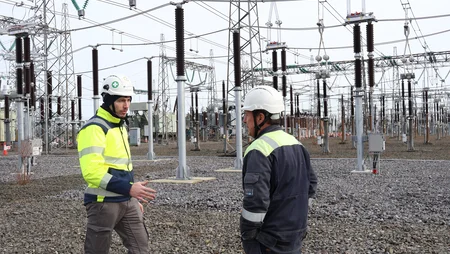 Two men in high viz out on site talking 