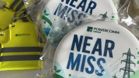 Cookie depicting power lines and wording "near miss" with high viz keyring